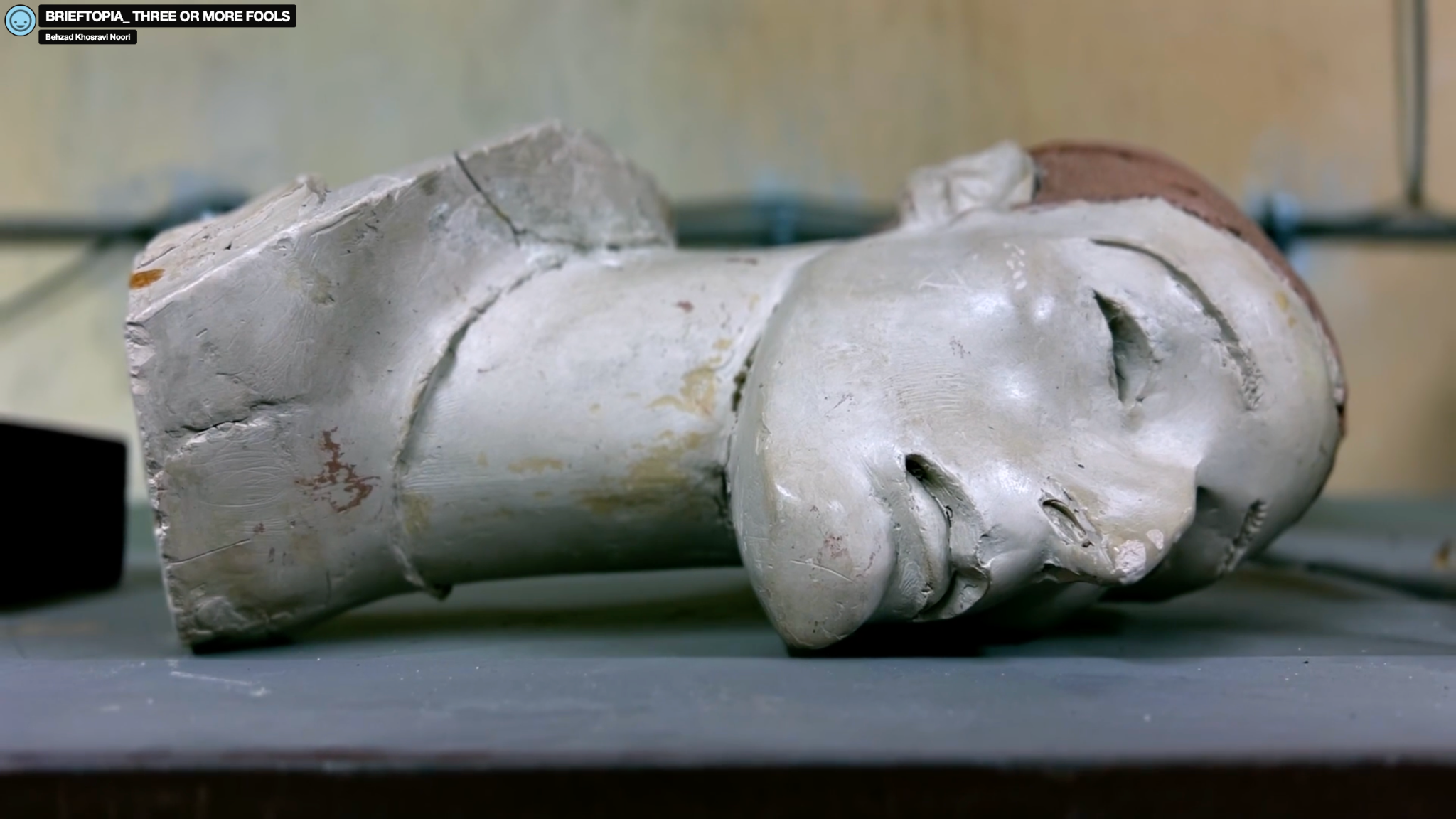 Film still showing a damaged sculptural figure